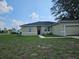 One story house with light beige exterior and a two-car garage at 120 Zinnia W Ln, Kissimmee, FL 34759