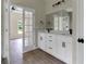 Modern bathroom with double vanity, white cabinets, and a large mirror at 556 Marion Oaks Pass, Ocala, FL 34473