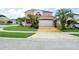 Two-story house with solar panels, landscaped lawn, and a large driveway at 11932 Old Glory Dr, Orlando, FL 32837