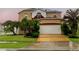Two-story house with solar panels, landscaped lawn, and a large driveway at 11932 Old Glory Dr, Orlando, FL 32837