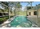 Kidney shaped pool with screened enclosure and patio at 607 Polynesian Ct, Kissimmee, FL 34758