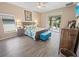 Main bedroom with a king-size bed, wood-look flooring, and access to a patio at 4423 Nottoway Dr, Leesburg, FL 34748