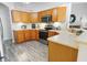 Kitchen with wood cabinets, stainless steel appliances, and laminate flooring at 4423 Nottoway Dr, Leesburg, FL 34748