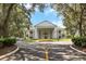 Community clubhouse with columns and circular driveway at 4423 Nottoway Dr, Leesburg, FL 34748