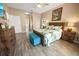 Main bedroom with king bed, wood floors, and access to the bathroom at 4423 Nottoway Dr, Leesburg, FL 34748