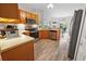 Kitchen with wood cabinets, stainless steel appliances, and laminate flooring at 4423 Nottoway Dr, Leesburg, FL 34748
