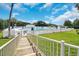 Inviting community pool area with a walkway and white fence at 4423 Nottoway Dr, Leesburg, FL 34748