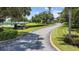 Landscaped entrance to the community with a curving road at 4423 Nottoway Dr, Leesburg, FL 34748