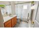 Clean bathroom with wood cabinets and vinyl plank flooring at 4423 Nottoway Dr, Leesburg, FL 34748
