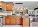 Kitchen boasts granite countertops, wood cabinets, and an island overlooking the living room at 12203 Pasha Ln, Orlando, FL 32827