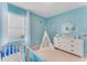 Bedroom with a crib, teepee, dresser, and ocean-themed wall decor at 3849 Malawi Trl, Saint Cloud, FL 34772