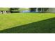 Large backyard with pond view and a wide expanse of grass at 2652 Carrickton Cir, Orlando, FL 32824