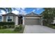 Gray house with a two-car garage and neatly landscaped yard at 2652 Carrickton Cir, Orlando, FL 32824