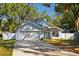 Two-story light blue house with a white garage door and landscaped yard at 4411 White Oak Cir, Kissimmee, FL 34746