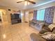 Bright living room with tile floors, comfortable couch, and large TV at 3804 Janie Ct, Orlando, FL 32822