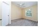 Bright bedroom with ceiling fan, grey tile floors, and a window with a view at 1932 Lake Atriums Cir # 86, Orlando, FL 32839
