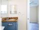 Bathroom with granite countertop, blue vanity, and a view of bedroom at 1932 Lake Atriums Cir # 86, Orlando, FL 32839