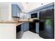 Modern kitchen featuring blue cabinets and black appliances at 1932 Lake Atriums Cir # 86, Orlando, FL 32839