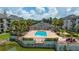 Community pool with clubhouse and lake view at 1932 Lake Atriums Cir # 86, Orlando, FL 32839