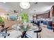 Open concept dining and living area with glass dining table and neutral colored sofa at 16486 Blooming Cherry Dr, Groveland, FL 34736