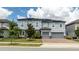 Two-story house with gray siding, solar panels, and two-car garage at 8324 Ludington Cir, Orlando, FL 32836