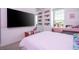 Bright bedroom with built-in shelves and a large TV at 8324 Ludington Cir, Orlando, FL 32836