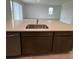 Kitchen island with white quartz countertops and dark brown cabinets at 27417 Black Kite Ave, Howey In The Hills, FL 34737