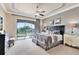 Spacious main bedroom with king-size bed and access to a balcony at 415 Muirfield Loop, Reunion, FL 34747