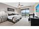 Main bedroom with king-size bed, balcony access, and TV at 415 Muirfield Loop, Reunion, FL 34747