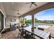 Outdoor patio with seating, dining areas, and a TV overlooking the pool at 415 Muirfield Loop, Reunion, FL 34747