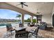 Covered patio with seating area, fire pit, and outdoor kitchen overlooking the pool at 415 Muirfield Loop, Reunion, FL 34747