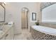 Elegant bathroom with a large soaking tub and a walk-in shower at 415 Muirfield Loop, Reunion, FL 34747
