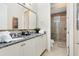 Double vanity bathroom with granite countertop and a walk-in shower at 415 Muirfield Loop, Reunion, FL 34747
