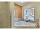 Bathroom with corner bathtub, shower, and bedroom view at 12544 Floridays Resort Dr # 203-B, Orlando, FL 32821