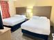 Bedroom with two double beds, nightstand, and lamp at 12544 Floridays Resort Dr # 203-B, Orlando, FL 32821