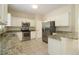 Kitchen boasts granite countertops, stainless steel appliances, and white cabinets at 276 Tavestock Loop, Winter Springs, FL 32708