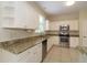 Well-lit kitchen with white cabinets, granite countertops, and stainless steel appliances at 276 Tavestock Loop, Winter Springs, FL 32708