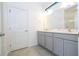Double vanity bathroom with gray cabinets and a large mirror at 5887 High Seas Dr, Orlando, FL 32821