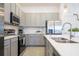 Modern kitchen with gray cabinets, stainless steel appliances, and white countertops at 5887 High Seas Dr, Orlando, FL 32821