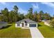 Single-story home with gray roof and attached garage, nestled in a wooded lot at 602 Marion Oaks Blvd, Ocala, FL 34473