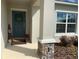 Covered entryway with blue door, stone accents, and fall decor at 5639 Costa Blanca Way, Davenport, FL 33897