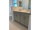 Double vanity bathroom with light gray cabinets and a large mirror at 5639 Costa Blanca Way, Davenport, FL 33897