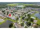 Aerial view showcasing the home's position in a community near a lake and tennis court at 4704 Cheyenne Point Trl, Kissimmee, FL 34746