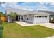 Single-story house with gray siding, a two-car garage, and well-maintained lawn at 4704 Cheyenne Point Trl, Kissimmee, FL 34746