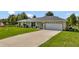 Single-story home with a two-car garage and a well-maintained lawn at 10604 Se 146Th Ln, Summerfield, FL 34491