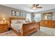 Main bedroom with king-size bed, wood furniture, and neutral carpeting at 10604 Se 146Th Ln, Summerfield, FL 34491