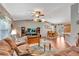Spacious living room with hardwood floors, large sectional sofa, and lots of natural light at 10604 Se 146Th Ln, Summerfield, FL 34491