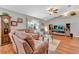 Spacious living room featuring hardwood floors, comfortable seating, and a large TV at 10604 Se 146Th Ln, Summerfield, FL 34491