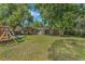 Spacious backyard with large trees and a playset at 233 S 4Th St, Lake Mary, FL 32746
