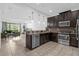 Modern kitchen with dark cabinets, granite countertops, and stainless steel appliances at 8110 Roseville Rd, Davenport, FL 33896